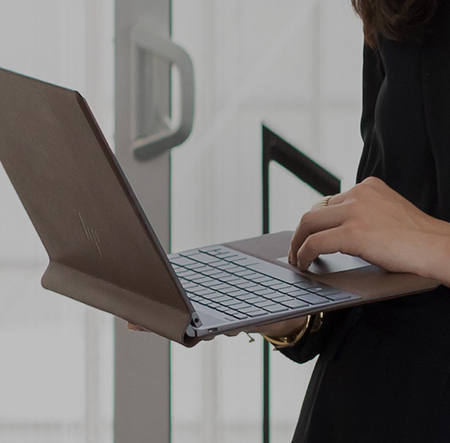 Spectre folio sleeve in person's hand sliding into tote